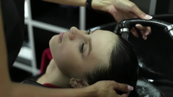 Hairdresser washes womans hair in the beauty studio — Stock Video