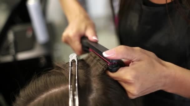Imagem de perto de uma mulher com o cabelo endireitado no salão de cabeleireiro. Foi filmado em câmara lenta. hd — Vídeo de Stock