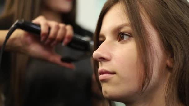 Primer plano de una mujer con el pelo alisado en la peluquería. Disparo en cámara lenta. hd — Vídeo de stock