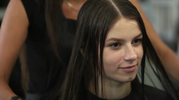 Jovem mulher no salão de cabeleireiro recebendo um corte de cabelo por cabeleireiro feminino — Vídeo de Stock