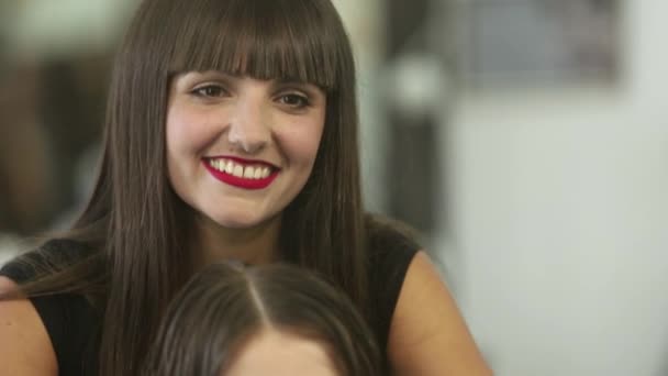 Mujer joven en el salón de belleza cortada por una peluquera — Vídeo de stock