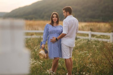 Ma ve onun hamile eşi tarlada çiftlik olarak stand ve birbirlerine sarılmak