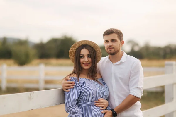 La familia feliz está esperando al bebé. Mujer embarazada y su marido en la naturaleza —  Fotos de Stock