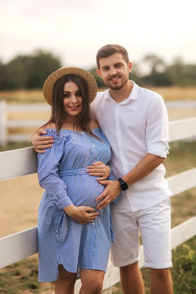 Une famille heureuse attend le bébé. Femme enceinte et son mari dans la nature — Photo