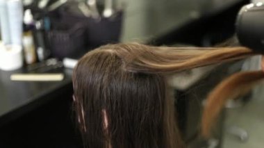 Profesyonel bayan kuaför saç kurutma makinesi kullanılır. Genç kızın saçlarını Kuaför salonu içinde giyinmiş. Bir hairdrye ile kadın stilist