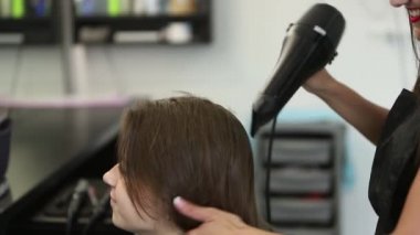 Profesyonel bayan kuaför saç kurutma makinesi kullanılır. Genç kızın saçlarını Kuaför salonu içinde giyinmiş. Bir hairdrye ile kadın stilist