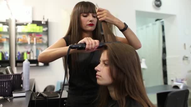 Jovem mulher no salão de cabeleireiro recebendo um corte de cabelo por cabeleireiro feminino — Vídeo de Stock