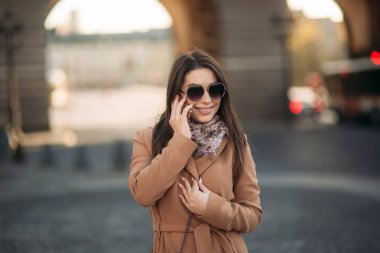 Çekici kız kullanım telefonu, şehir merkezinde. Sonbahar hava