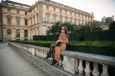 Şık kız ceket poz için fotoğrafçı büyük park yakınındaki. güneşli havalarda ve güzel model