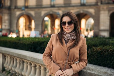 Şık kız ceket poz için fotoğrafçı büyük park yakınındaki. güneşli havalarda ve güzel model