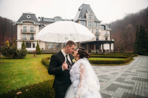Noiva e noivo andando no parque no dia do casamento. Tempo de outono. Rair. Guarda-chuva casal — Fotografia de Stock