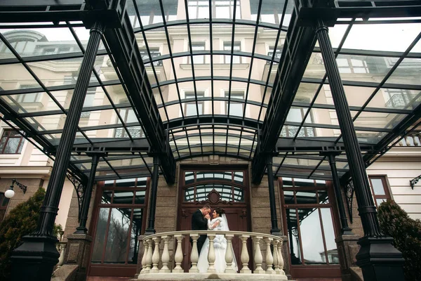 Casal stand perto de grande edifício em seu dia do casamento — Fotografia de Stock