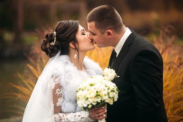 Um casal feliz a passear no dia do casamento. Grande parque com grande castelo. Tempo de outono e fundo colorido — Fotografia de Stock