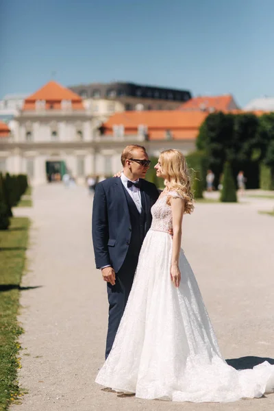 Bruidegom dans met bruid in de pakr in de buurt van het paleis in Wiena, Oostenrijk — Stockfoto