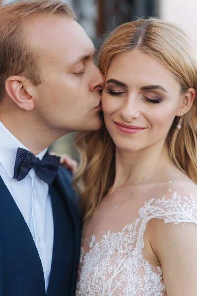 Um homem beija a mulher no dia do casamento. Casal bonito — Fotografia de Stock