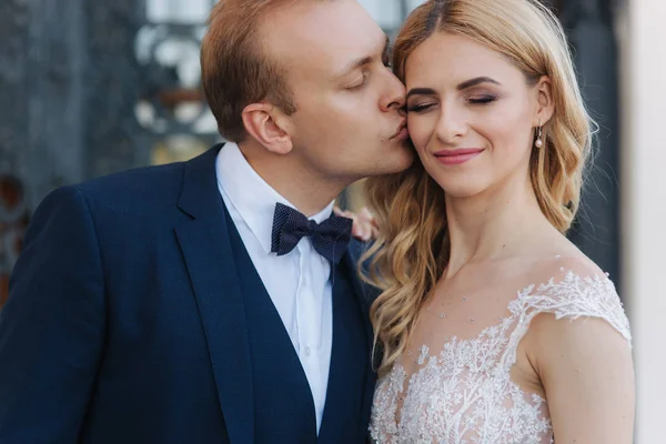 Muž políbil svou ženu v jejich svatební den. Krásný pár — Stock fotografie
