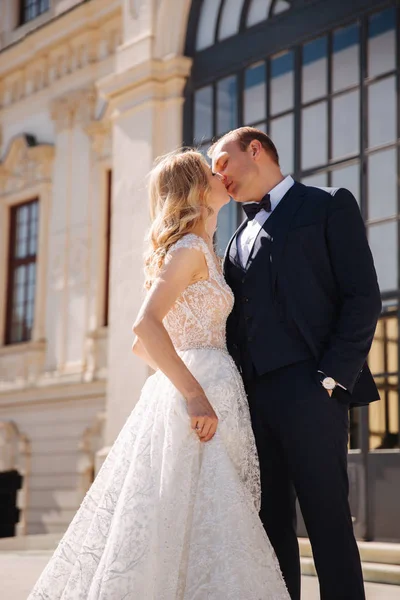 Casamento elegante coupele stand em escadas perto do grande palácio — Fotografia de Stock