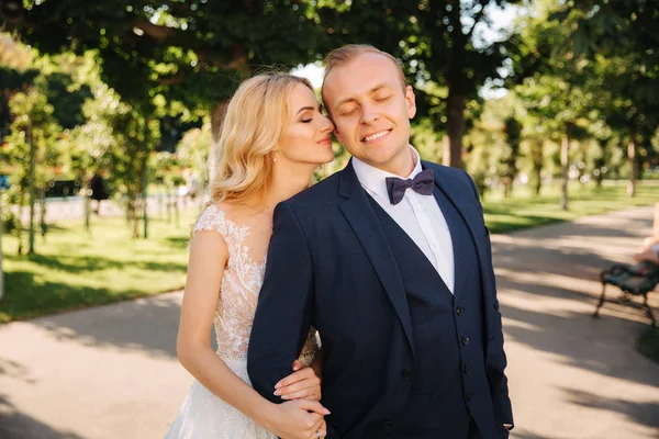 Feliz pareja joven en el día de su boda pasar tiempo en el parque. Fondo verde — Foto de Stock