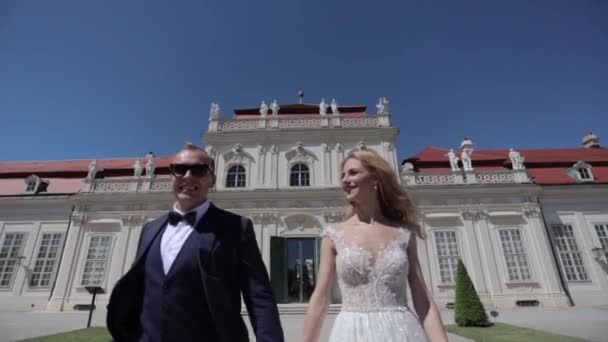 Belle jeune mariée avec son beau marié marchant dans le palais Belvédère. Vidéo HD — Video