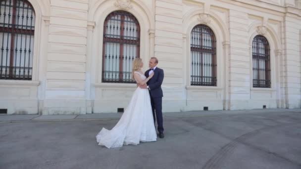Schöne junge Braut mit ihrem gutaussehenden Bräutigam, der im Belvedere des Palastes spaziert. hd video — Stockvideo