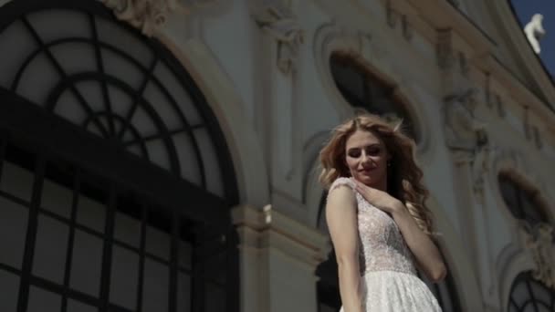 Hermosa novia en vestido de novia de lujo delante del palacio — Vídeos de Stock