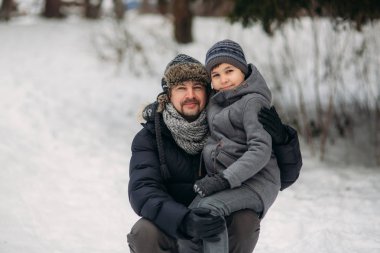 Mutlu baba oğluyla karlı kış hava parkta size yürür