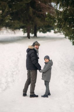 Mutlu baba oğluyla karlı kış hava parkta size yürür