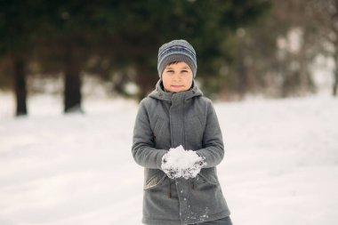 Küçük bir çocuk kış hava Parkta yürüyüşleri, oyun snowballs ve sevindiler. Noel ruh için bekliyor