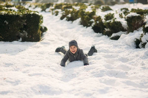 Ein Junge springt in Winterkleidung in den Schnee — Stockfoto