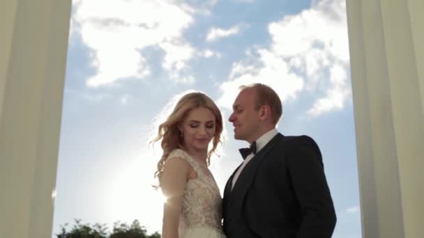 Man and woman in wedding clother stand near the big pillar — Stock Video