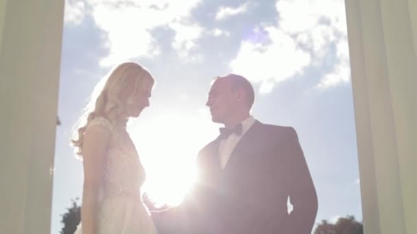 Man en vrouw in het huwelijk clother staan in de buurt van de grote pijler — Stockvideo