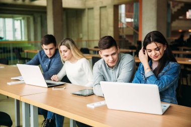 Üniversite öğrencilerinin okul Kütüphanesi, bir kız ve bir erkek eğitim grup olup bir dizüstü bilgisayar kullanarak Internet'e bağlanma