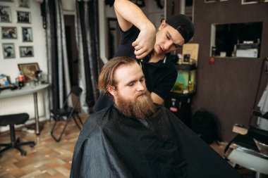 Erkek müşteri kuaför tarafından tıraş ediliyor. berber dükkanı