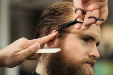 Genç Kuaför berber dükkanı çekici sakallı adam saçını yapmasını eller