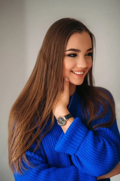 Ritratto della giovane bella donna sorridente dentro. Ragazza col maglione di Bkue. Trucco moda — Foto Stock