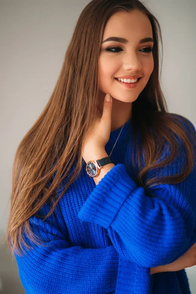 Portret młodej kobiety piękne uśmiechający się wewnątrz. Dziewczyna w bkue swetrze. Mody makijaż — Zdjęcie stockowe