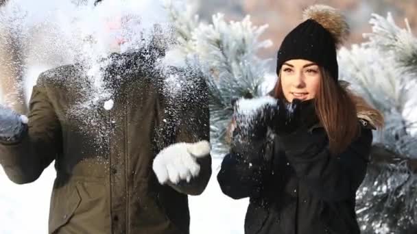 Een verliefde paar in sprookjesachtige winterweer speelt sneeuwballen. Slow motion — Stockvideo