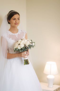 Genç ve hassasiyet gelin gelinlik buket tutun. Onu düğün günü mutlu gelin