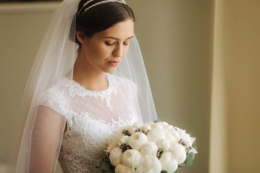 Genç ve hassasiyet gelin gelinlik buket tutun. Onu düğün günü mutlu gelin