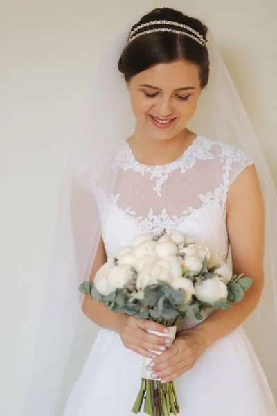 年轻温柔的新娘穿着婚纱, 拿着花束。幸福的新娘在她的婚礼上 — 图库照片
