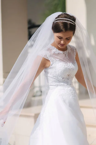 Jovencita el día de su boda. Novia feliz posa a fotógrafo y sonrisa —  Fotos de Stock