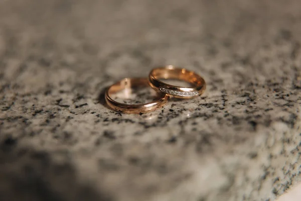 Vigselringar på bordet. Guldringar med diamant på solen. Bröllop accsessories. makro — Stockfoto