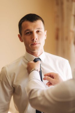 Düğün gününde tişörtlü yakışıklı adam. O stand duymak pencere