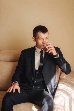 Damat kanepe ve drind üzerinde bir wiskey oturur