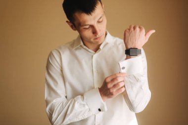 Yakışıklı damat düğün gününde. Adam sabah sabah üstünü giyiniyor