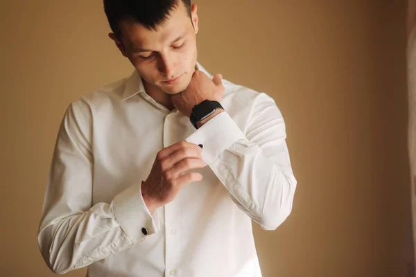 Un hombre guapo con camisa el día de su boda. Él está de pie escuchar la ventana —  Fotos de Stock