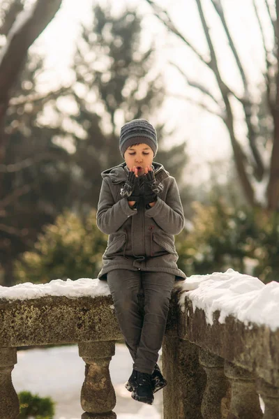 Μικρό αγόρι του πλανήτη στα χέρια του. Καιρός χειμώνα. Χιόνι στη γύρω περιοχή — Φωτογραφία Αρχείου