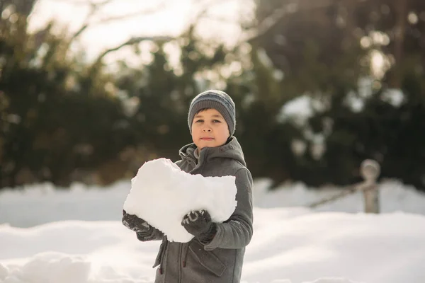 Malý chlapec hra se sněhem. On se sněhové koule a hrát — Stock fotografie