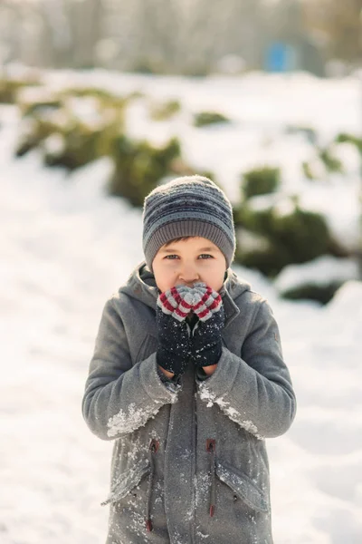 Um menino aquece as mãos do frio no inverno — Fotografia de Stock