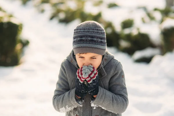 Chlapec si ohřívá ruce před zimou — Stock fotografie